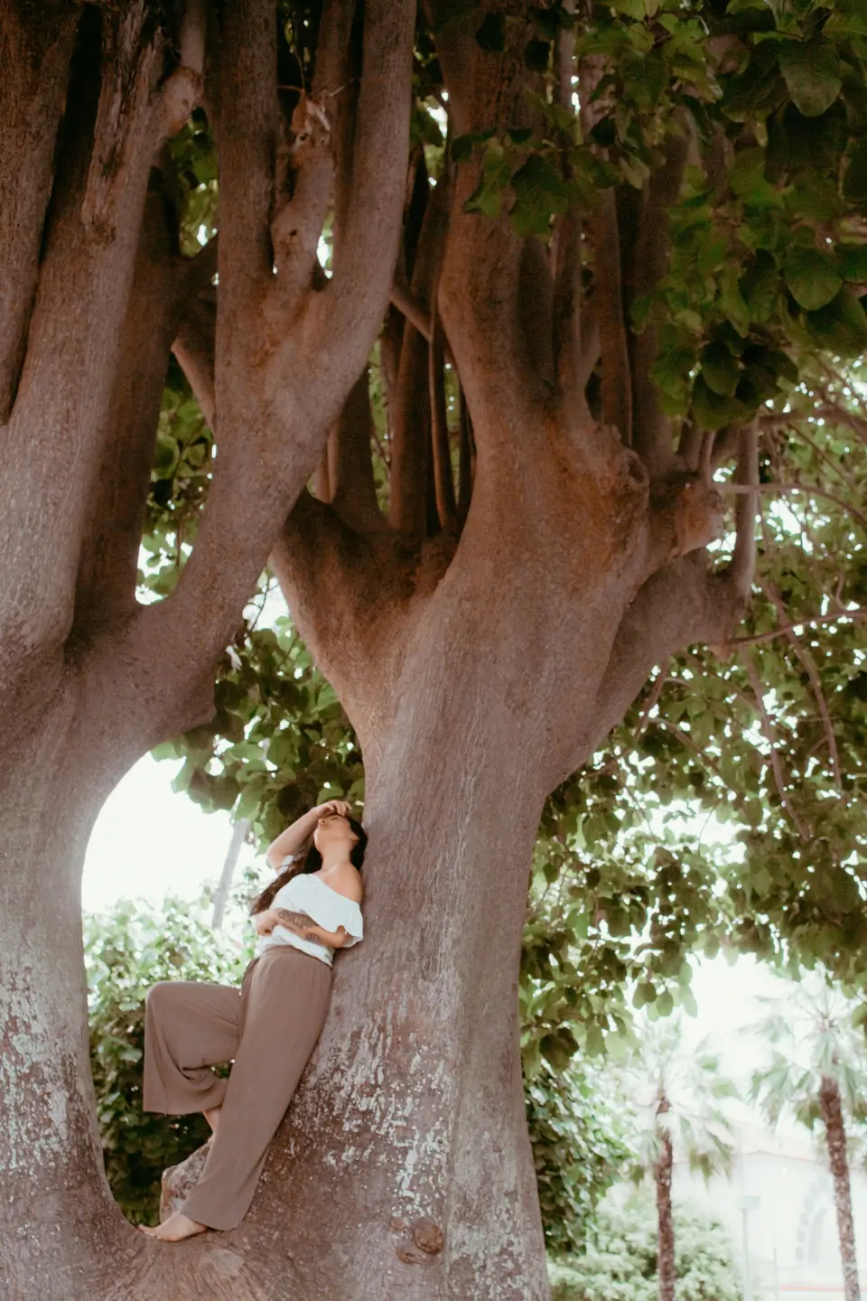 Fiorella Lertora recostada en el tronco de un árbol grande